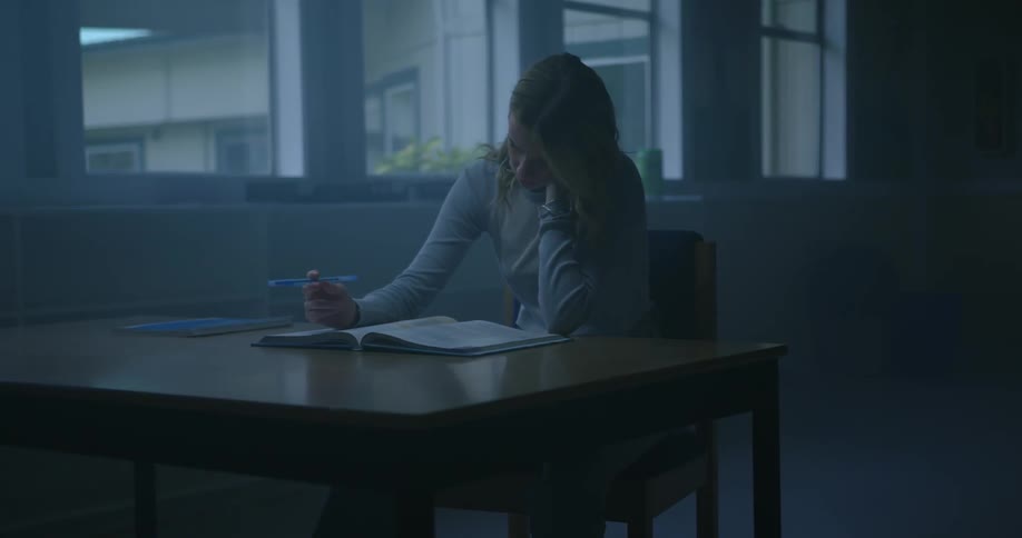 A girl is reading a textbook in the classroom