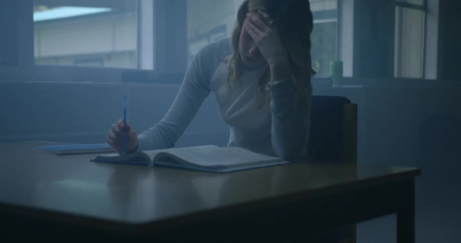 A girl is reading a textbook in the classroom