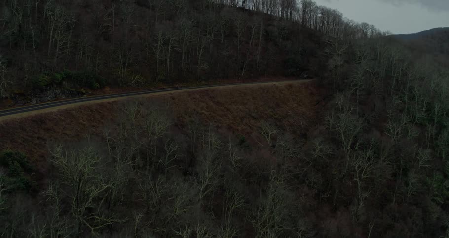 Aerial view of traintracks on the slopes of a mountain at evening