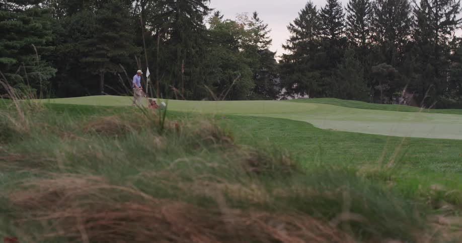 Man mowing the grass on a golf course