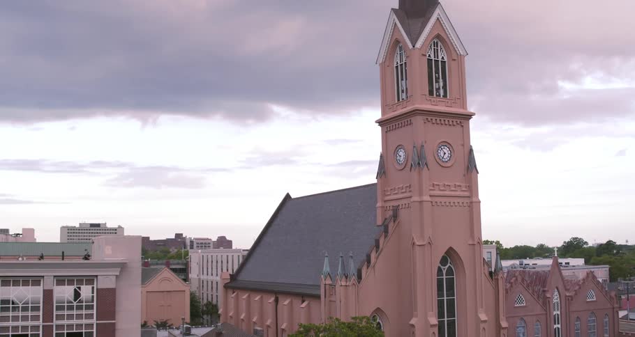 Aerial view of the clock tower of a curch in a small town at evening
