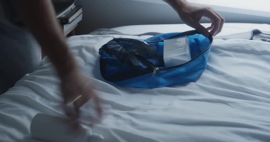 A person packing things into a bag
