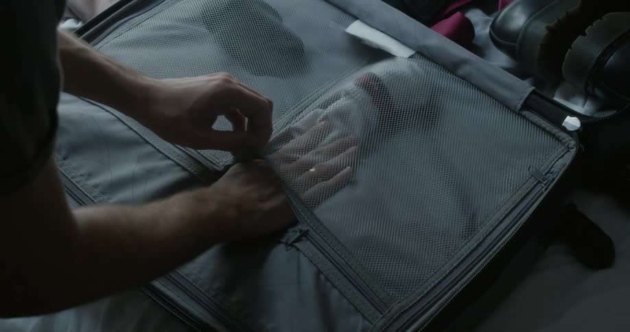 Person packs socks into suitcase