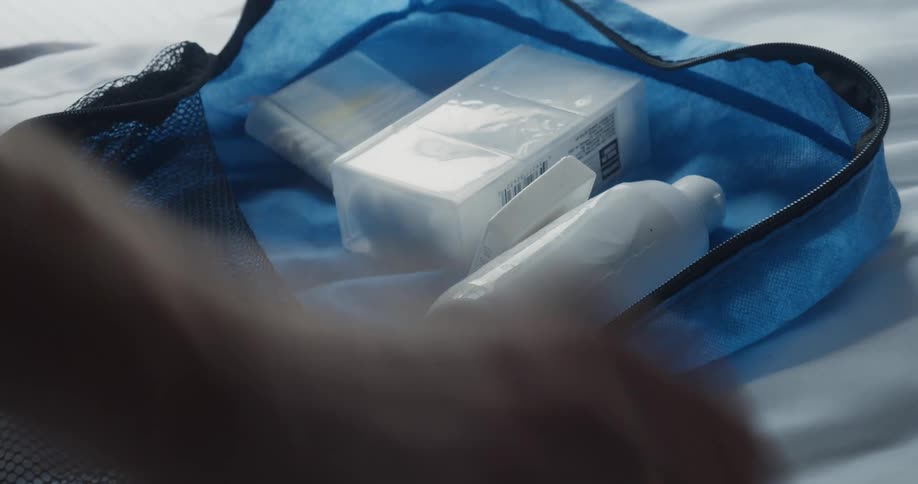 A person is packing a small bag for travel
