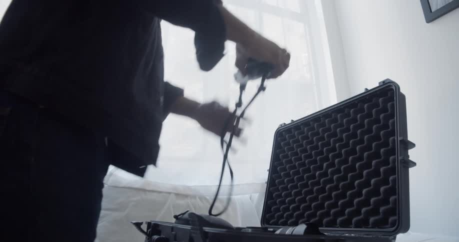 A man is putting a camera in his case