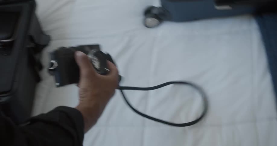 A photographer packs the parts of a camera in a padded carrying case