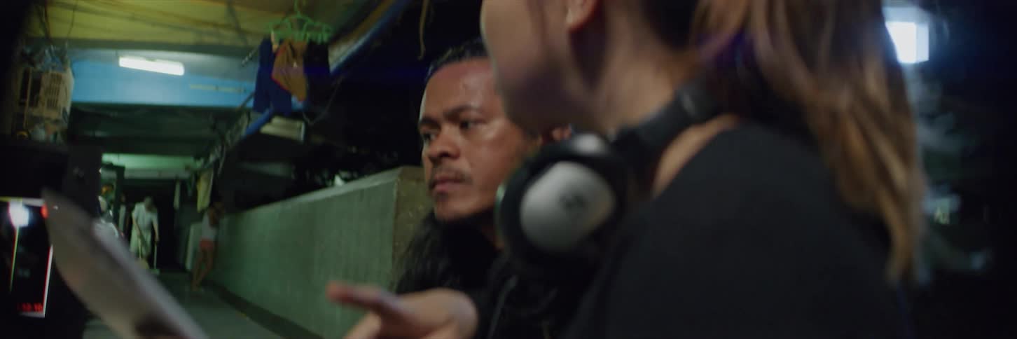 Members of camera crew view screen and hold discussion