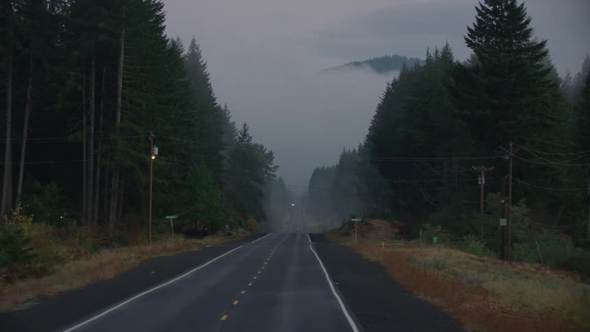 Traveling on an empty foggy two lane highway in an eerie early morning shot that feels a lot like Halloween