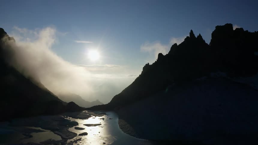 The clouds sit below the mountain peak
