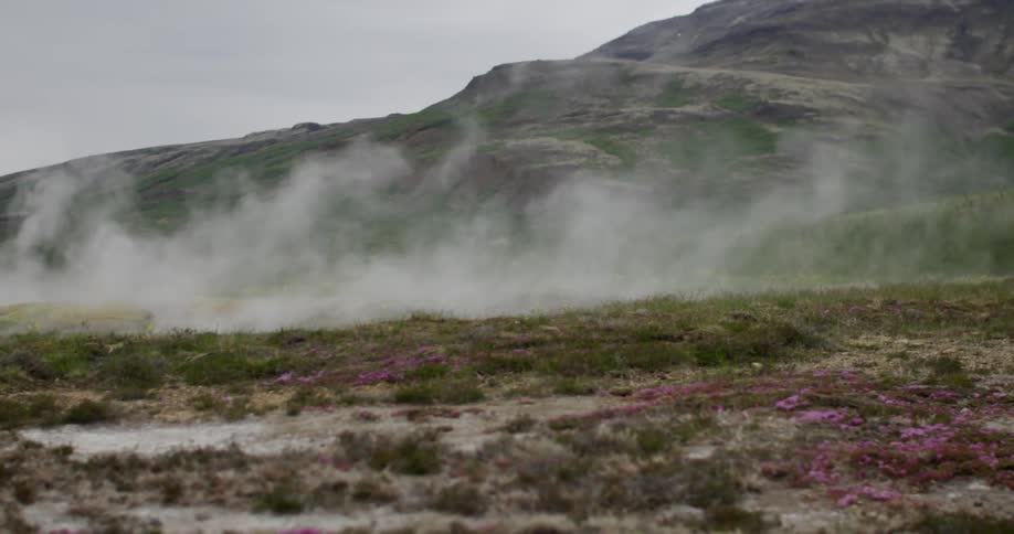 Dust blowing across the ground at the base of a hill