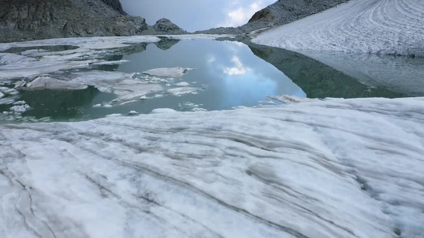 An aerial view of a glacier on some water