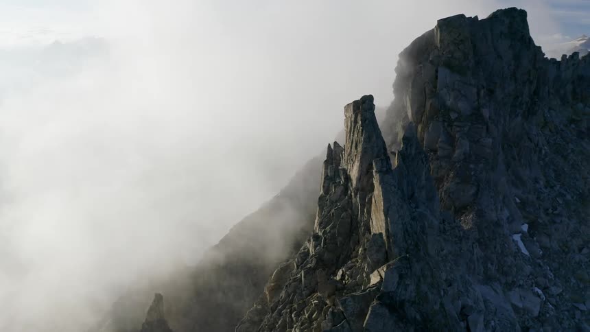 Mountain ridge peaking high in a cloudy sky