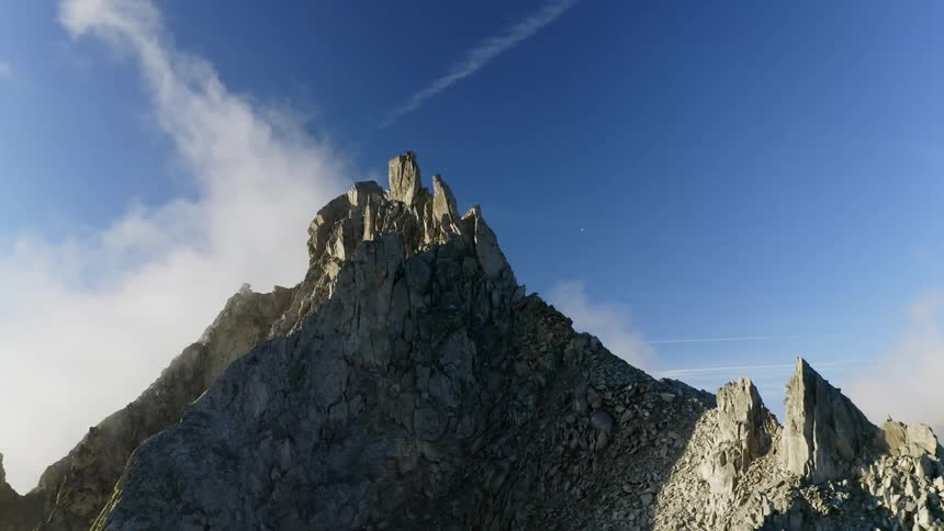 Mountains with peaks high in a cloudy blue sky