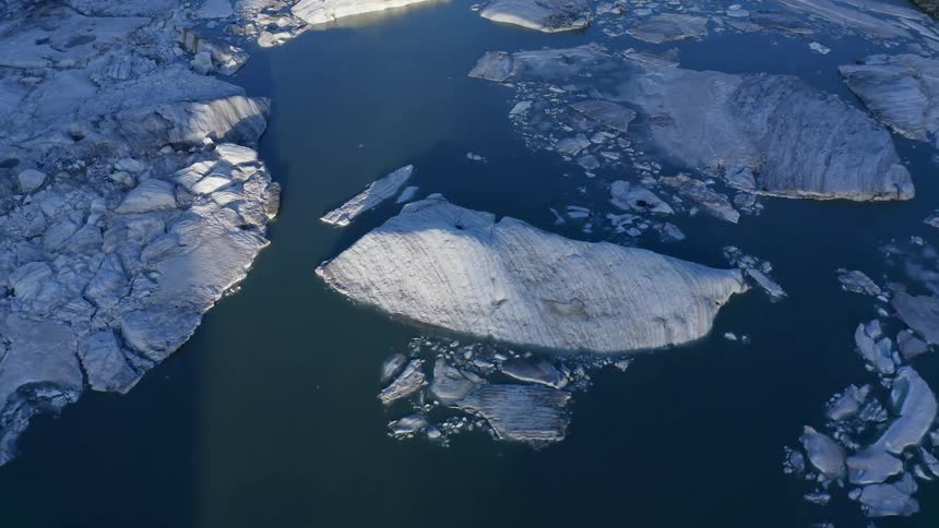 Broken chunks of snow and ice settle in still open waters