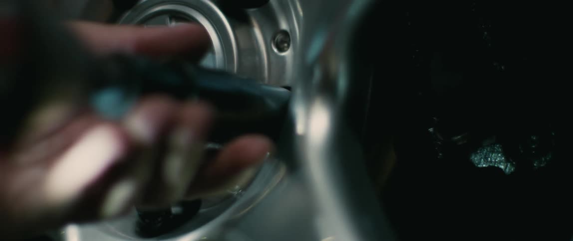 A person putting wheels on a car