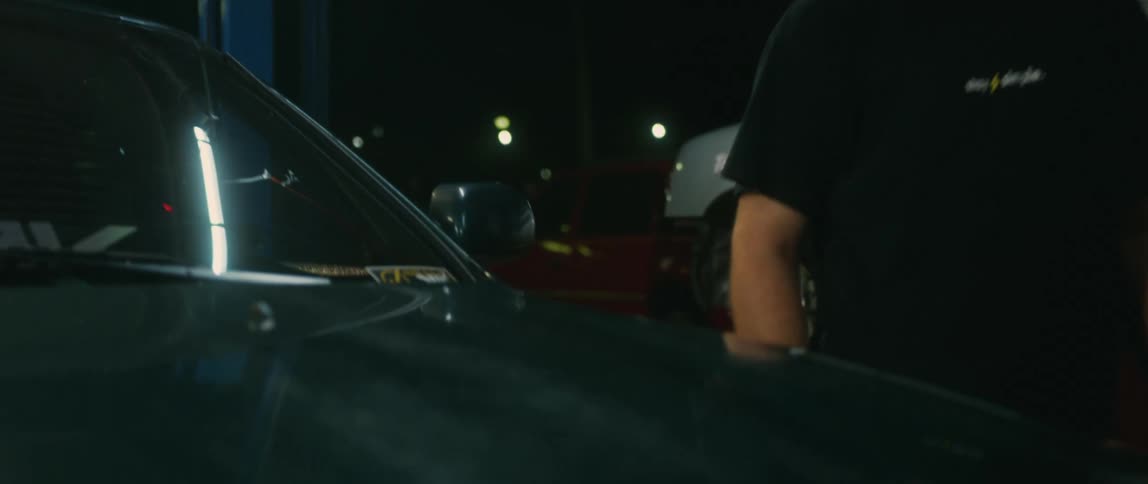 A man walking up and touching a car