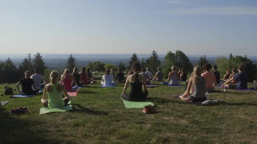 People sitting on blankets with their legs crossed outdoors