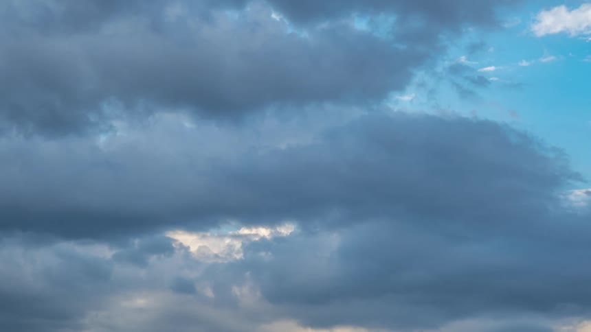 Gray storm clouds gather in blue sky