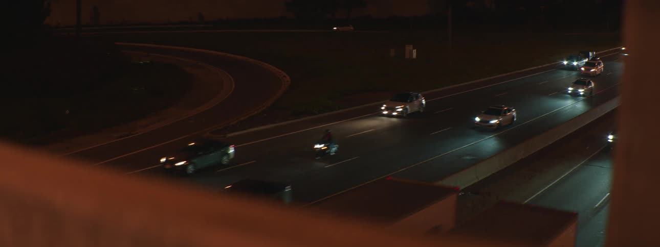 A view of highway traffic at night as seen from an overpass