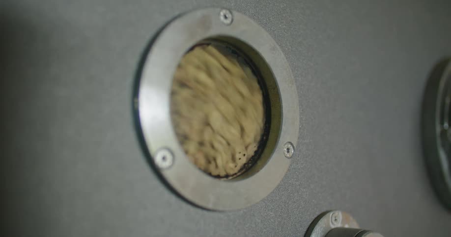 Coffee beans are seen spinning in an industrial roaster