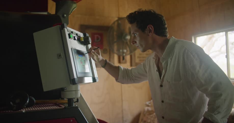 A man uses a stylus on a boxy touchscreen