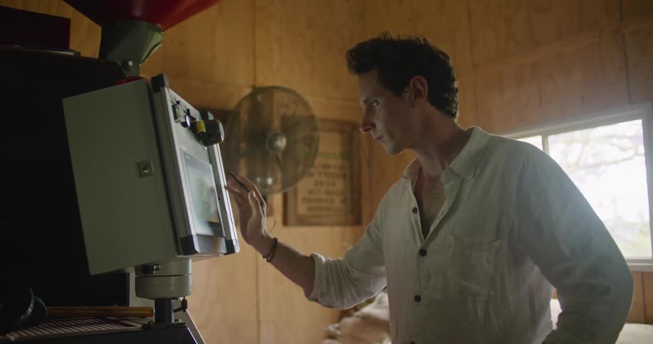 Man stands in room manipulating machine settings