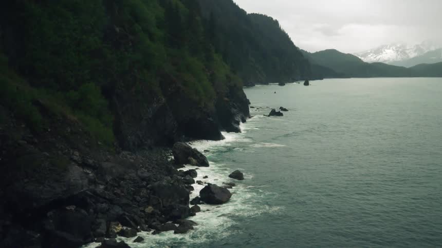 Waves crash into rocks along a coastal promontory