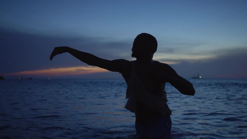 A man is practicing tai chi in the water