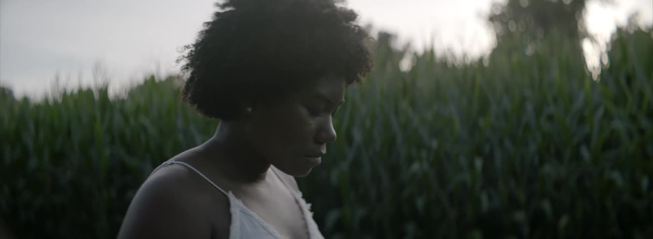 Woman standing outside by a corn field