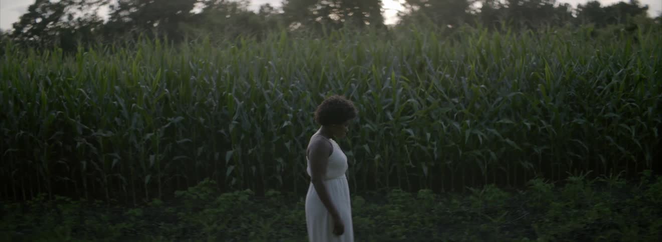 Woman standing outside by a corn field