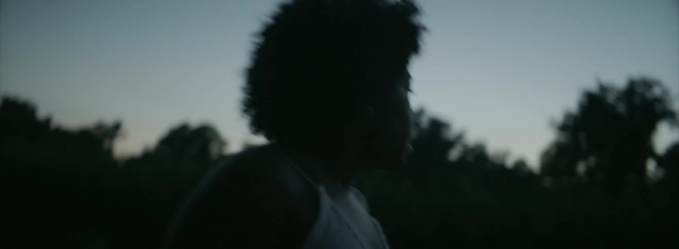 Nervous woman pacing outside at dusk as a bat flies by