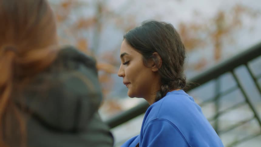 Two women talk as they sit outside