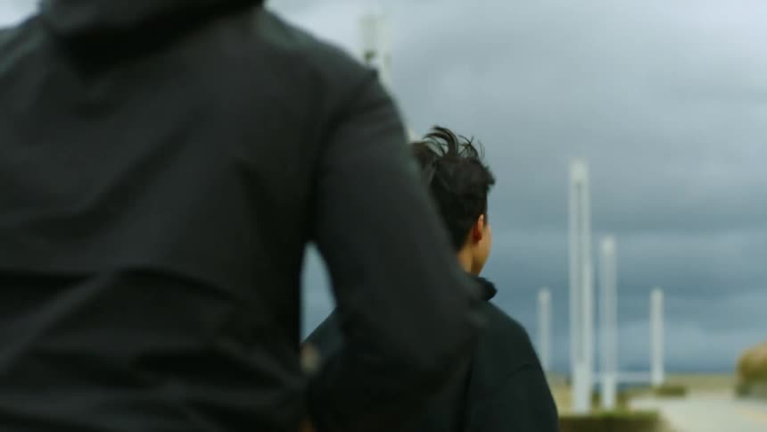 Friends wearing black clothes jogging together on an overcast day