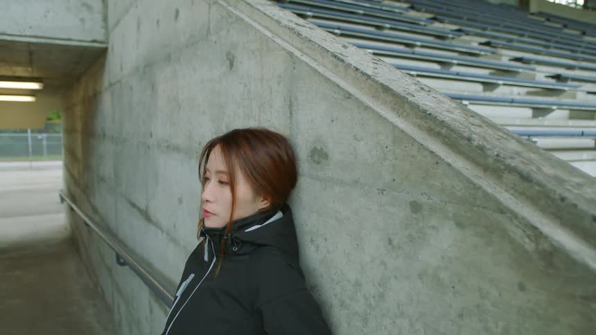 A woman is leaning against the wall
