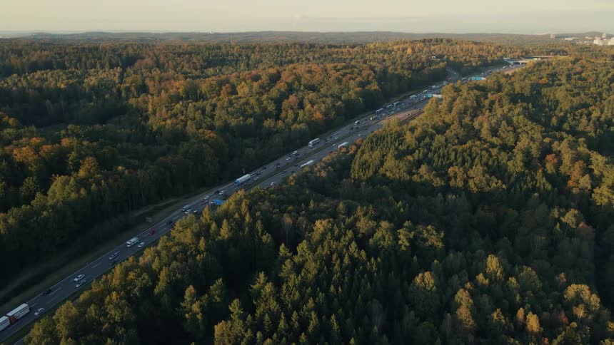 Aerial view of a busy highway and trees along the side of the road in fall colors