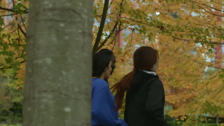 Friends jog through park toward river