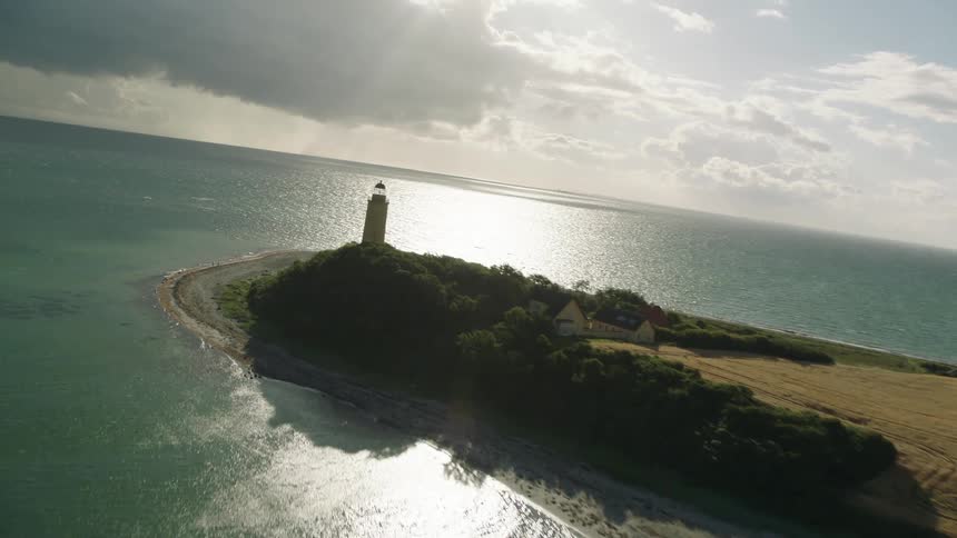 The lighthouse is on the edge of the shore