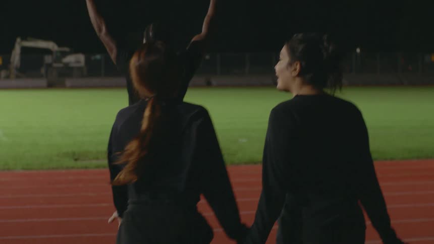 A group of friends walk on the running track and cheer
