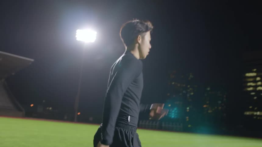 A man walks on the field at night