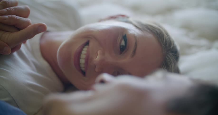 Two people smiling and laughing while holding hands