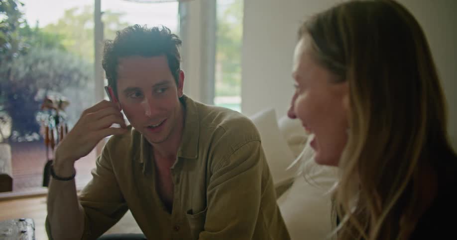 Young couple talking while sitting in a couch at home