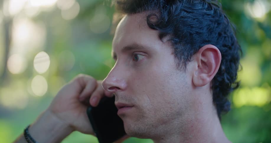 A man is outside talking on his cellphone