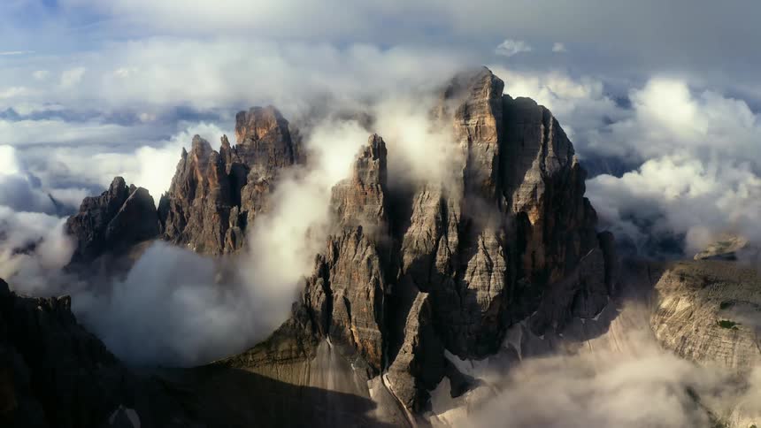 Low lying clouds over part of jagged mountains