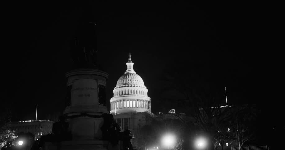 The statue sits in the dark by the building