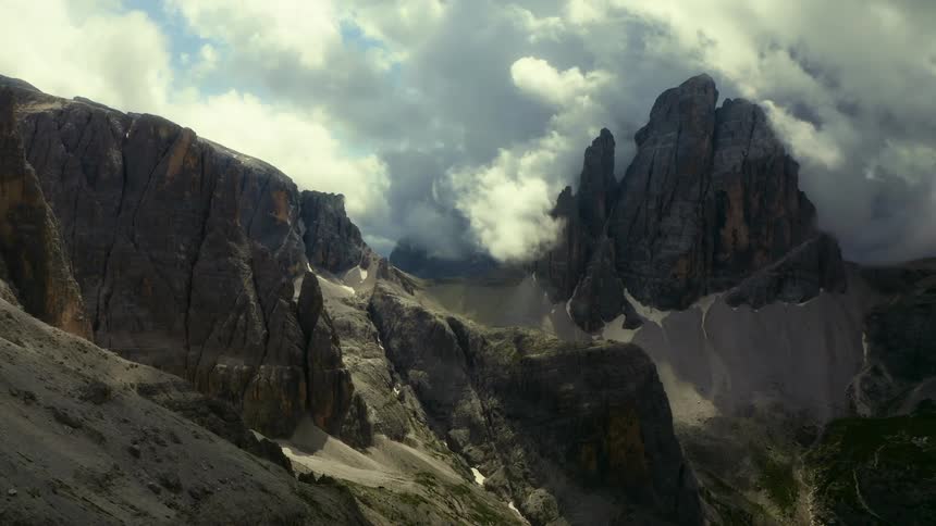 A steep mountain peak under heavy dark clouds