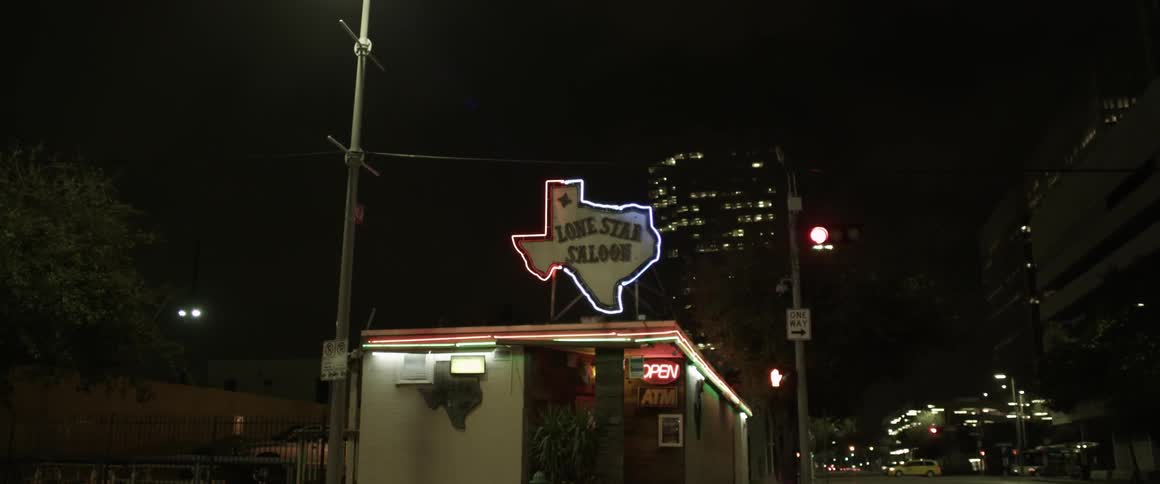 A store has a lit sign at night