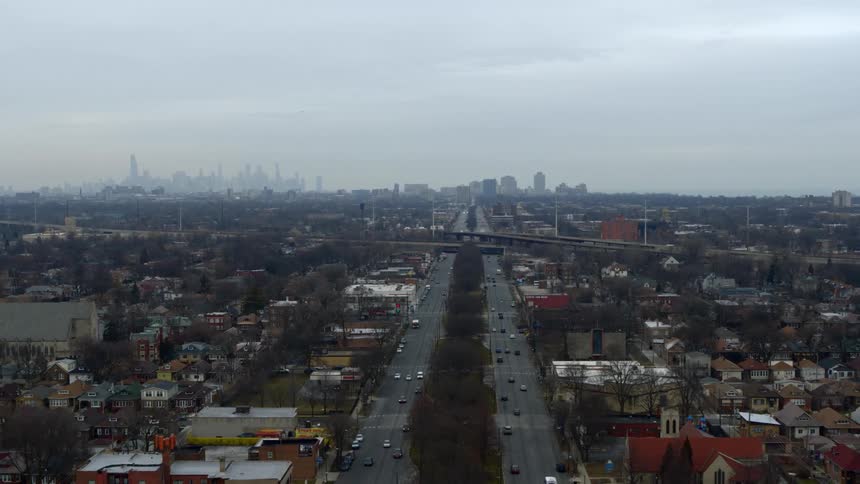 Aerial view of traffic in an urban area and a city skyline far in the distance