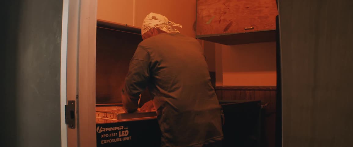A man puts a frame on a machine