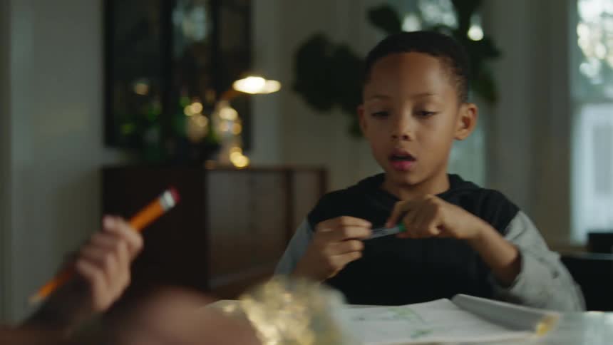 A girl spills a glass of orange juice on her homework papers