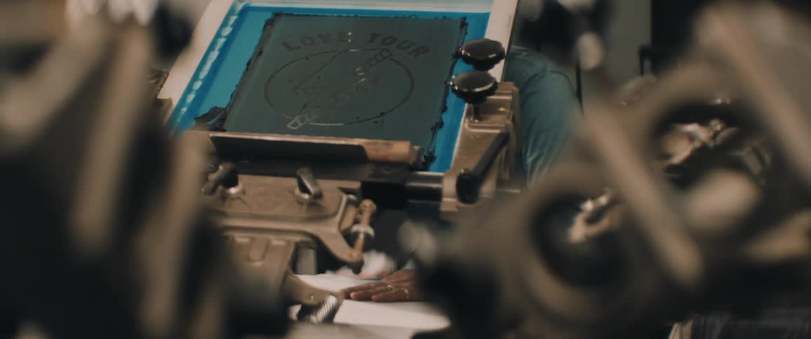 An employee working a screen printer